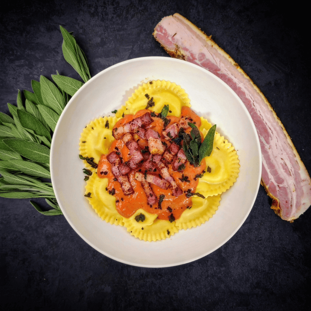 Ravioli met traag gegaard buikspek, gegrilde honingtomaatjes en krokante salie