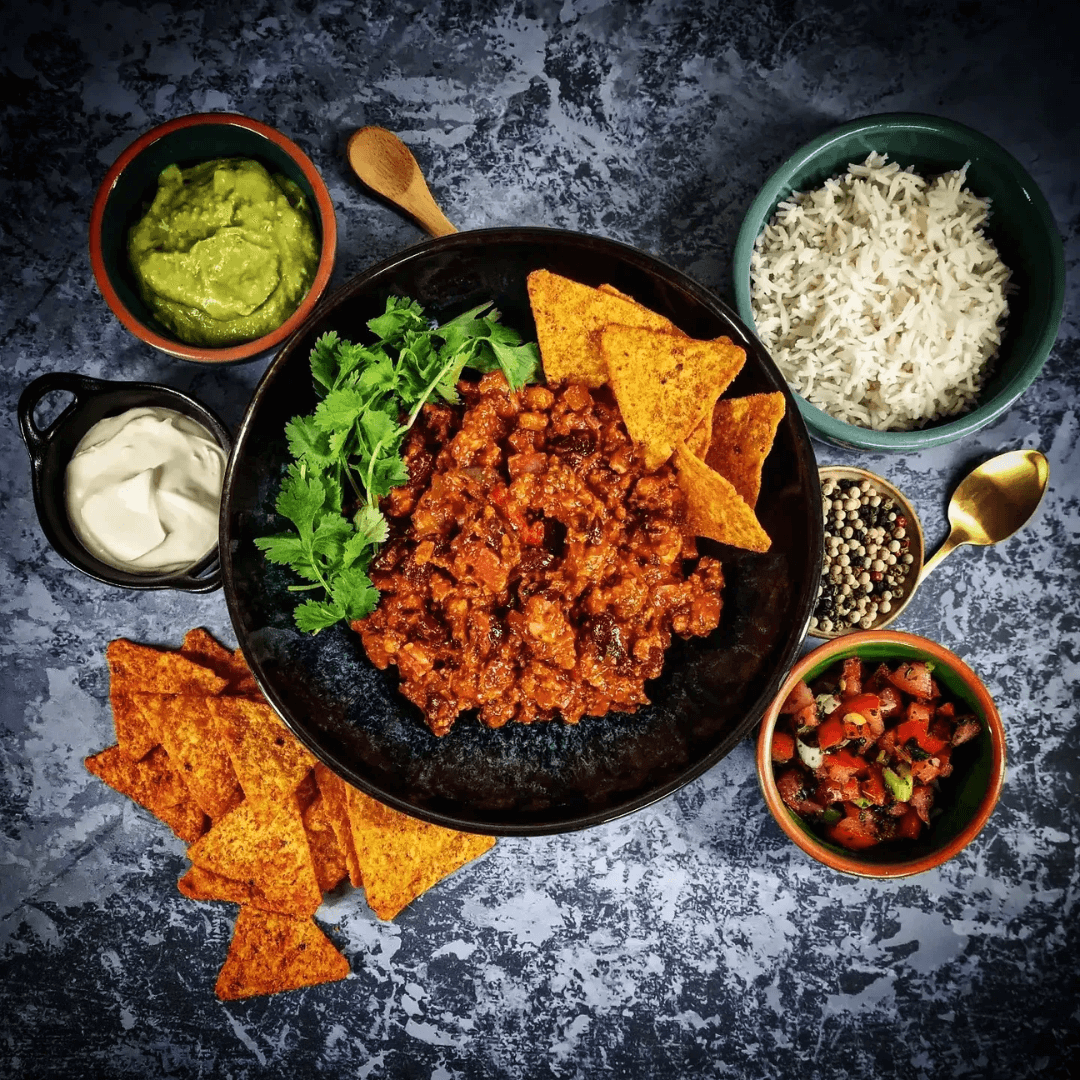 Chili con carne met spekjes, bonen en kruiden, geserveerd met koriander