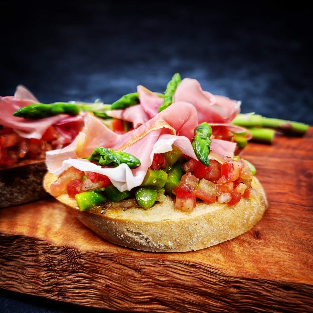 Bruschetta met Sint-Antoniusham, tomatensalsa en groene asperges op ciabatta – vers bereid door Keurslager De Meulder Brasschaat