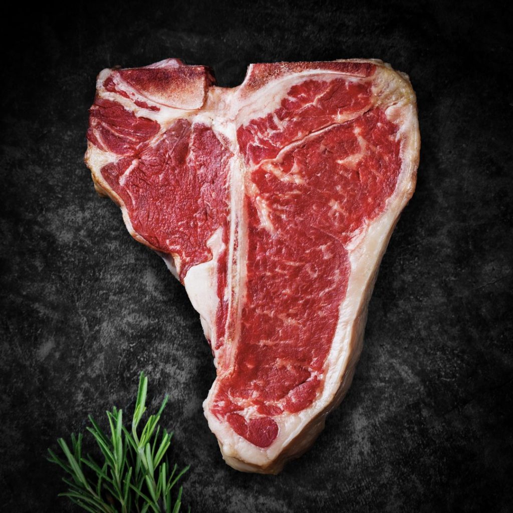 Rauwe T-bone steak met bot op donkere achtergrond