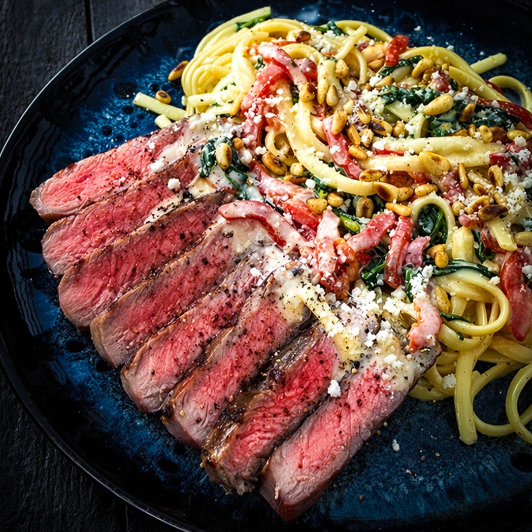 Romige linguine met spinazie gegrilde paprika en entrecote van de barbecue