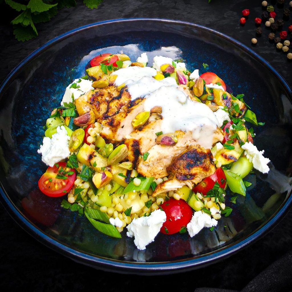 Salade met kruidige kip en parelcouscous, feta en pistache